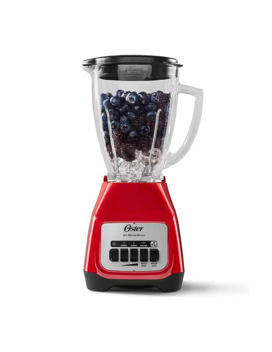 Licuadora roja Oster Kaliman con vaso de vidrio transparente y frambuesas en su interior.