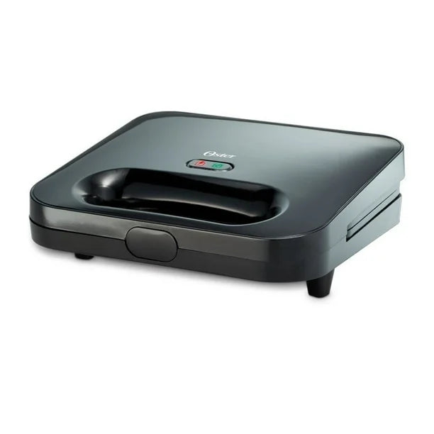Sandwichera compacta Oster negra con mango integrado y luces indicadoras de encendido y listo.