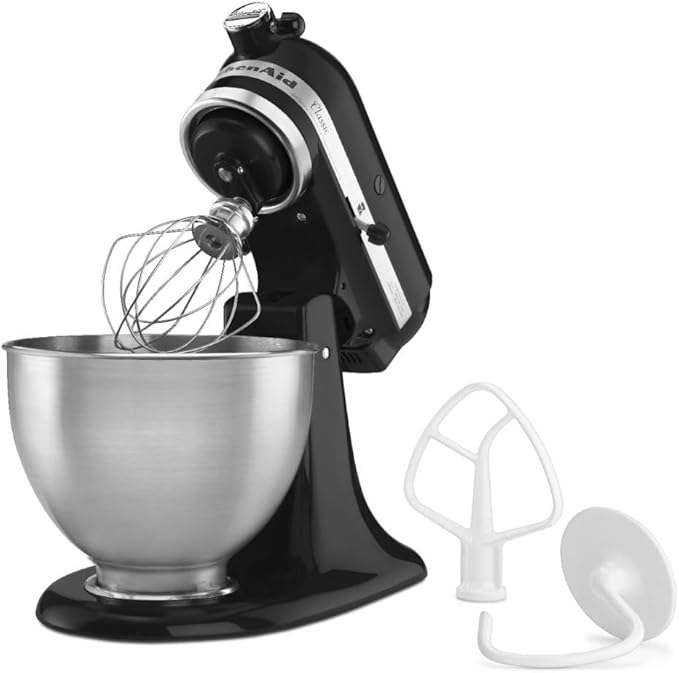 Batidora de pie negra KitchenAid con bol de acero inoxidable y accesorios de batidor, pala y gancho amasador.