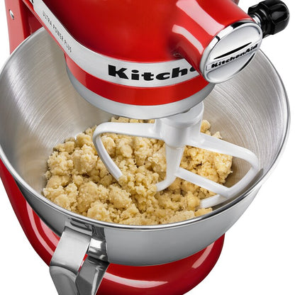 Batidora de pie KitchenAid roja con tazón de acero inoxidable y mezcla de masa gruesa.