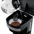 Cafetera programable Hamilton Beach negra con jarra de vidrio y café cayendo en 12 tazas.