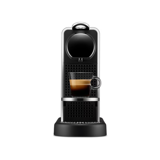 Cafetera Nespresso Citiz color plata con bandeja de goteo y espresso servido en vaso transparente.