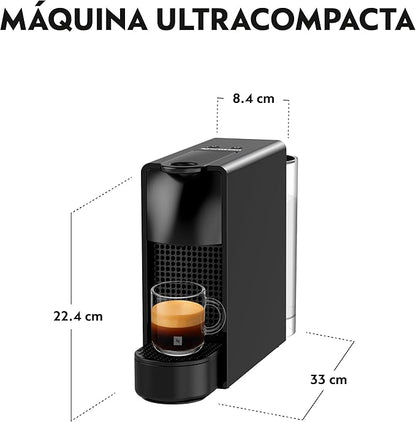 Cafetera Nespresso Essenza Mini negra ultra compacta con depósito de agua y vaso medidor con espresso crema intensa.