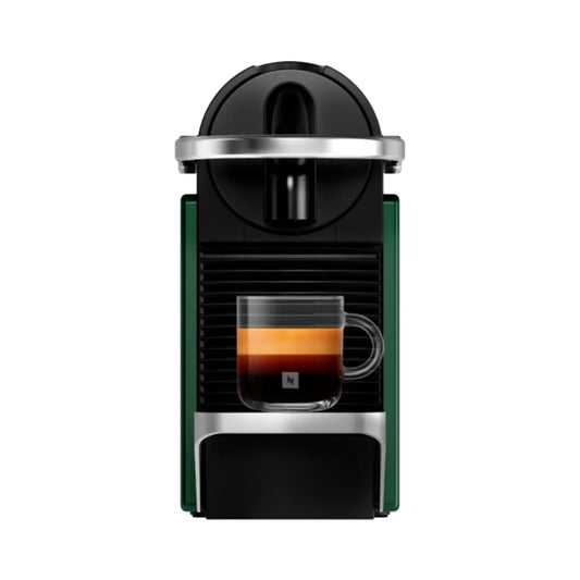 Cafetera Nespresso Pixie verde compacta con taza de espresso transparente y detalles en negro y plata.