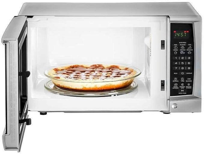 Microondas GE compacto color blanco con puerta abierta y pizza adentro, panel digital negro a la derecha.