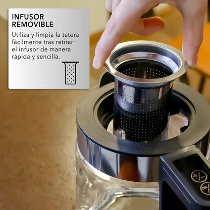 Mano quitando infusor negro perforado de tetera digital RCA con jarra de vidrio transparente y base negra.
